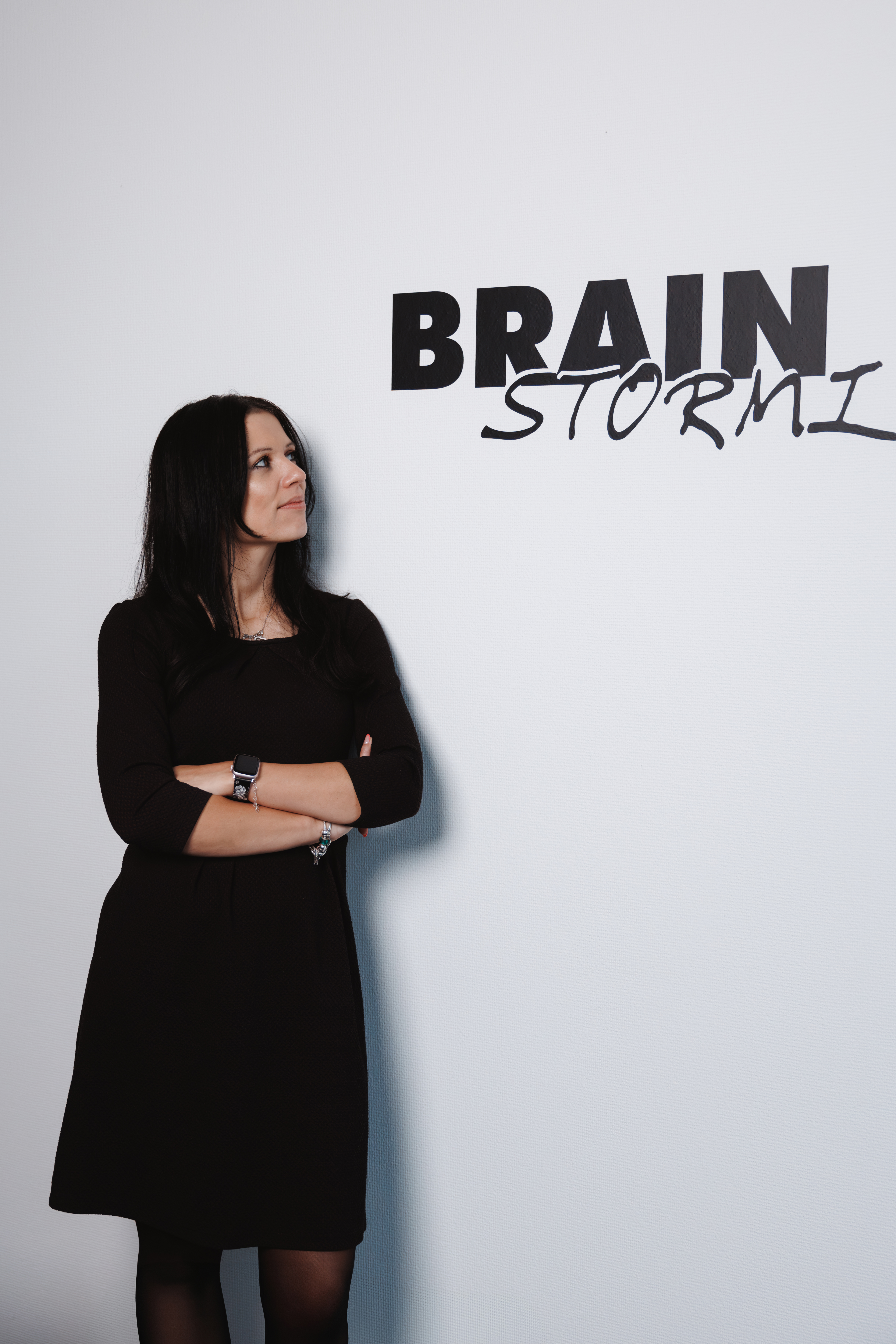 Stephanie Kröning lehnt an einer Wand mit dem Schriftzug Brainstorm